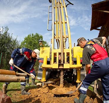 Монтажная бригада выполняет обсадку скважины трубами